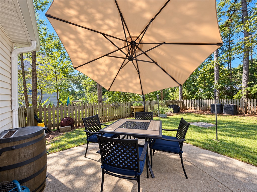 113 Grand Oak Circle Pendleton, SC 29670 - Photo 8 of 25 An inviting concrete patio overlooks the fully fenced grassy backyard bordered by mature trees.