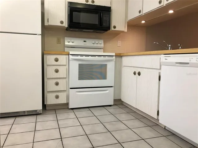 a bedroom with a bed and a lamp on dresser