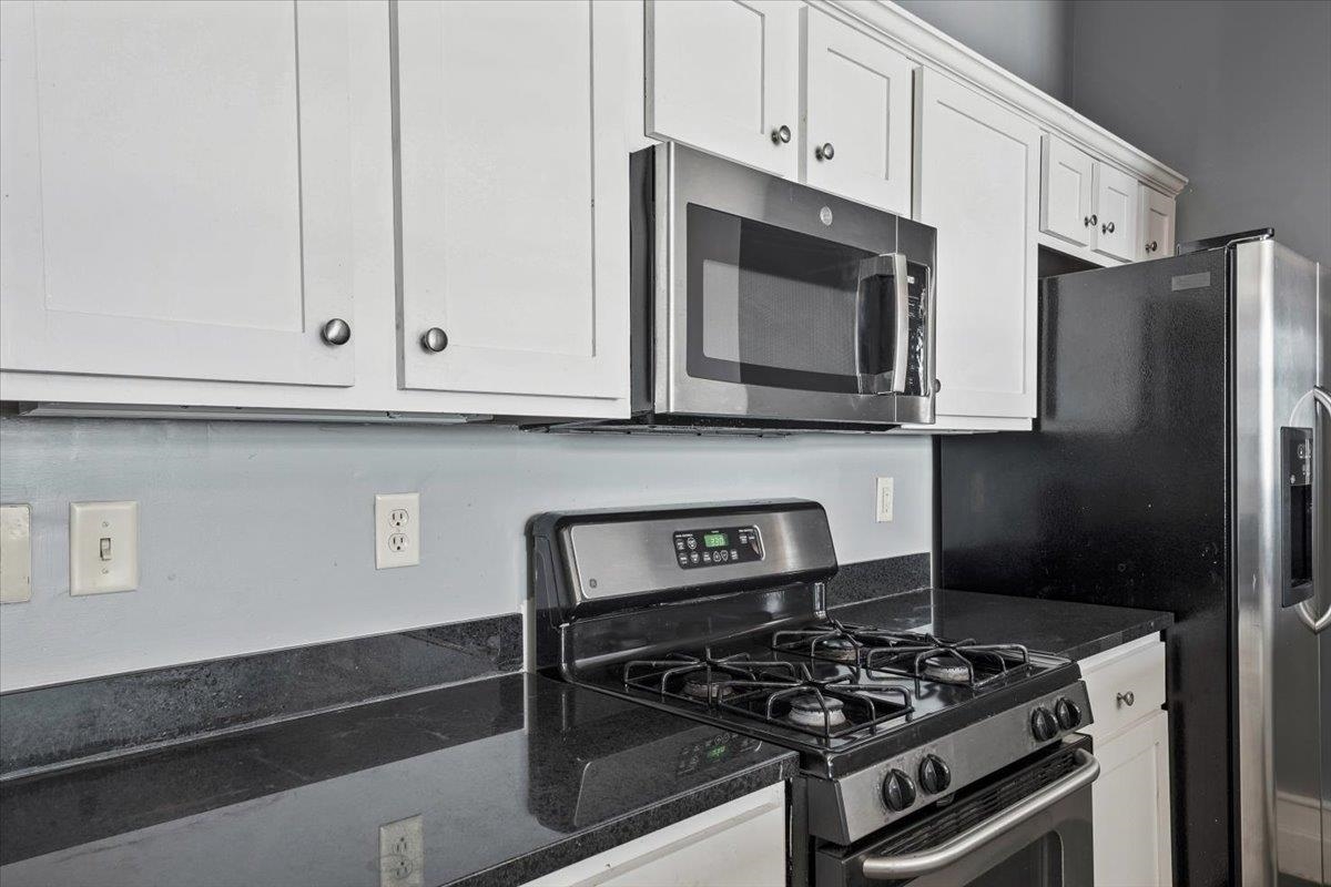 648 Riverside Drive, Unit 207 Memphis, TN 38103 - Photo 20 of 34 a kitchen with stainless steel appliances granite countertop white cabinets and black stove top oven with granite countertops