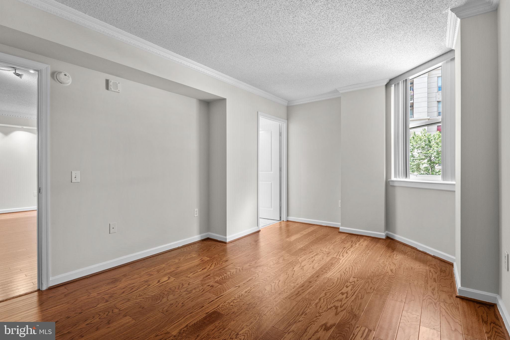 880 North Pollard Street, Unit 224 Arlington, VA 22203 - Photo 15 of 50 a view of an empty room with wooden floor and a window