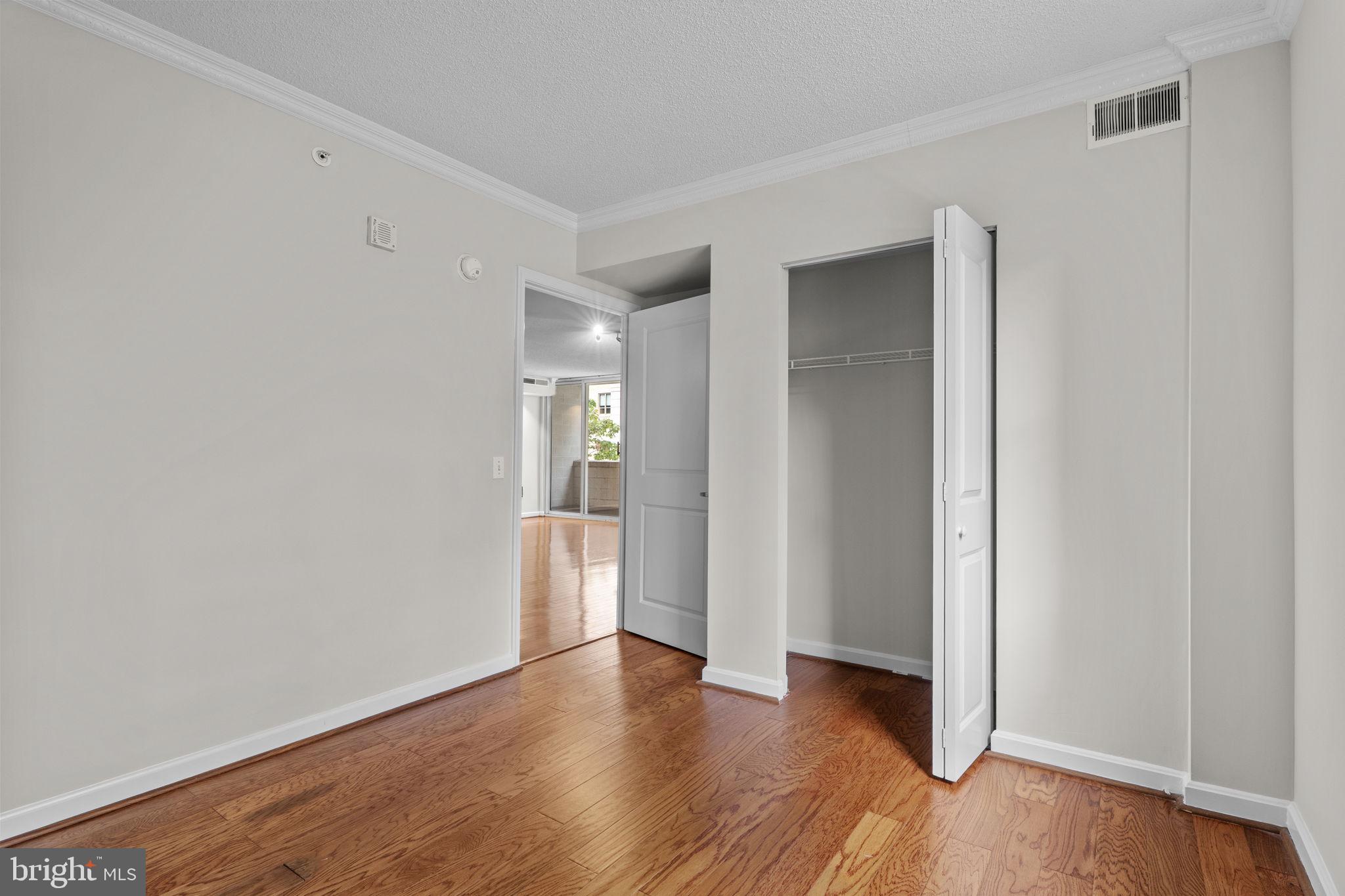 880 North Pollard Street, Unit 224 Arlington, VA 22203 - Photo 22 of 50 a view of an empty room with wooden floor and a window