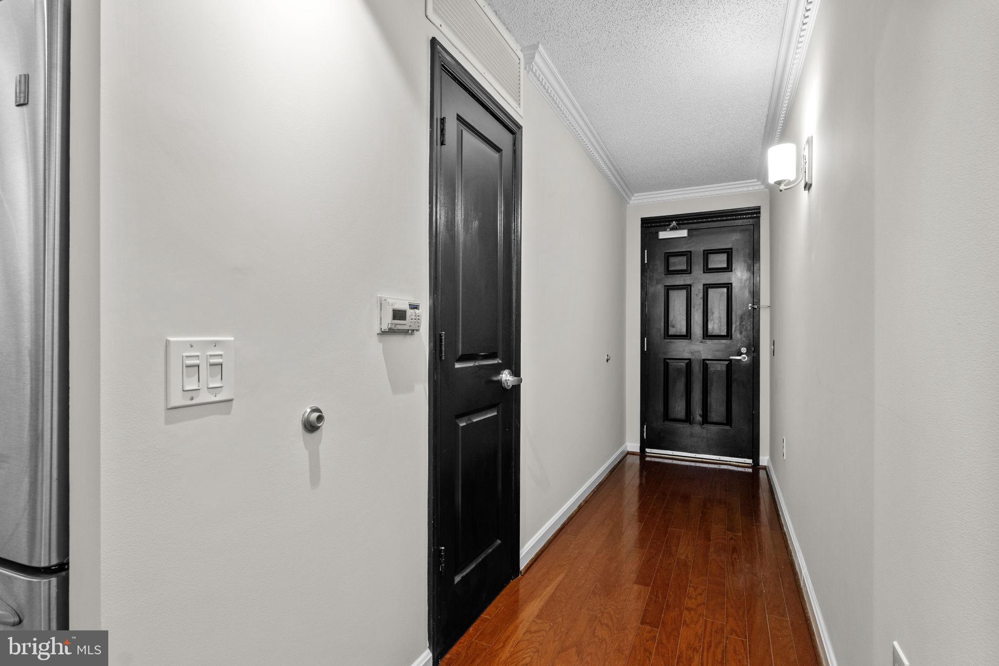 880 North Pollard Street, Unit 224 Arlington, VA 22203 - Photo 3 of 50 a view of a hallway with wooden floor and a bathroom