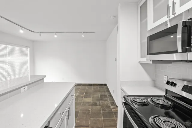 a stove top oven sitting inside of a kitchen