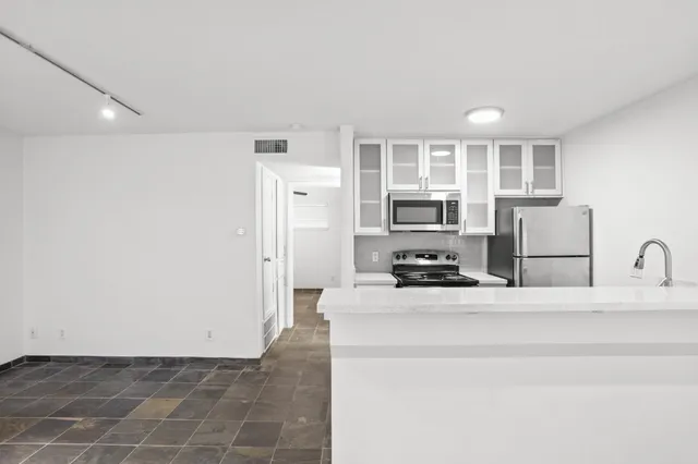 a kitchen with a refrigerator and a stove top oven