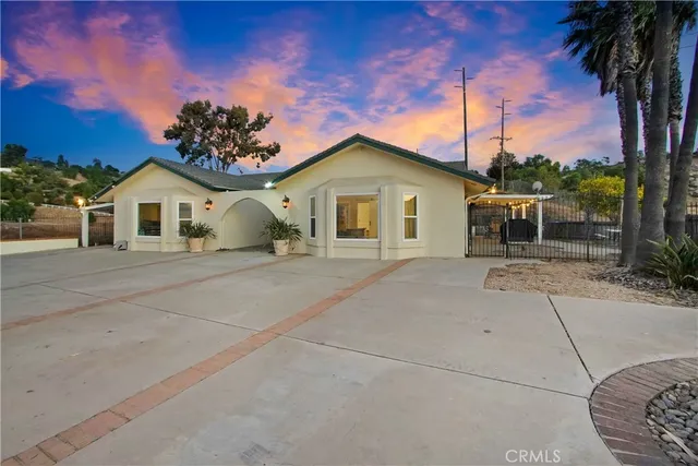 a front view of a house with a garden and trees