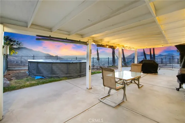 a view of a patio with table and chairs under an umbrella