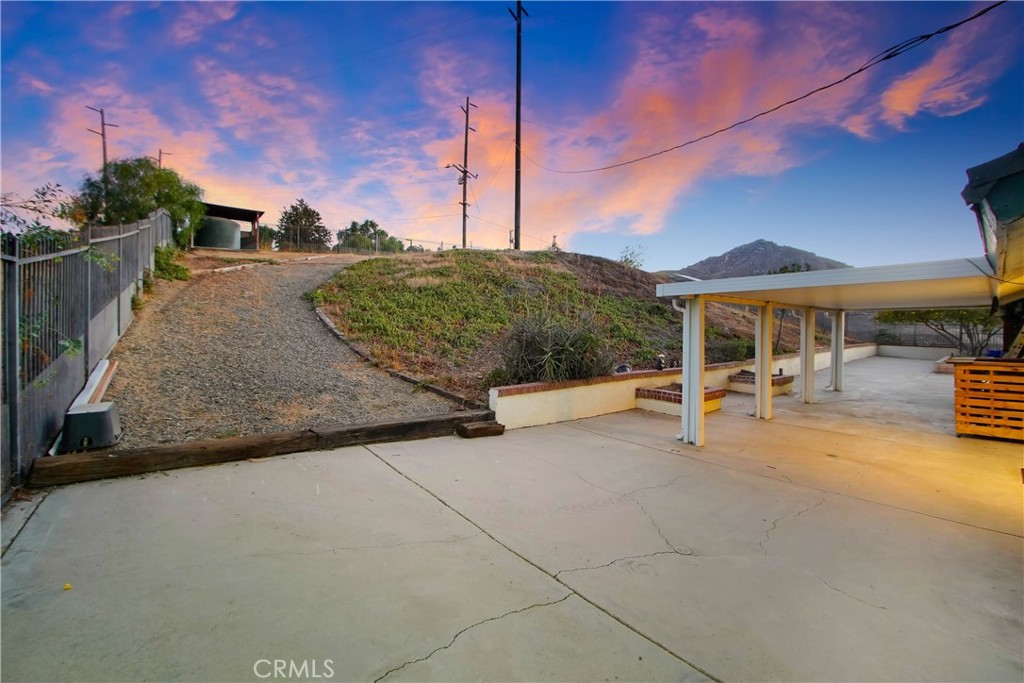8555 Pigeon Pass Road Moreno Valley, CA 92557 - Photo 31 of 63 a view of a patio with table and chairs under an umbrella