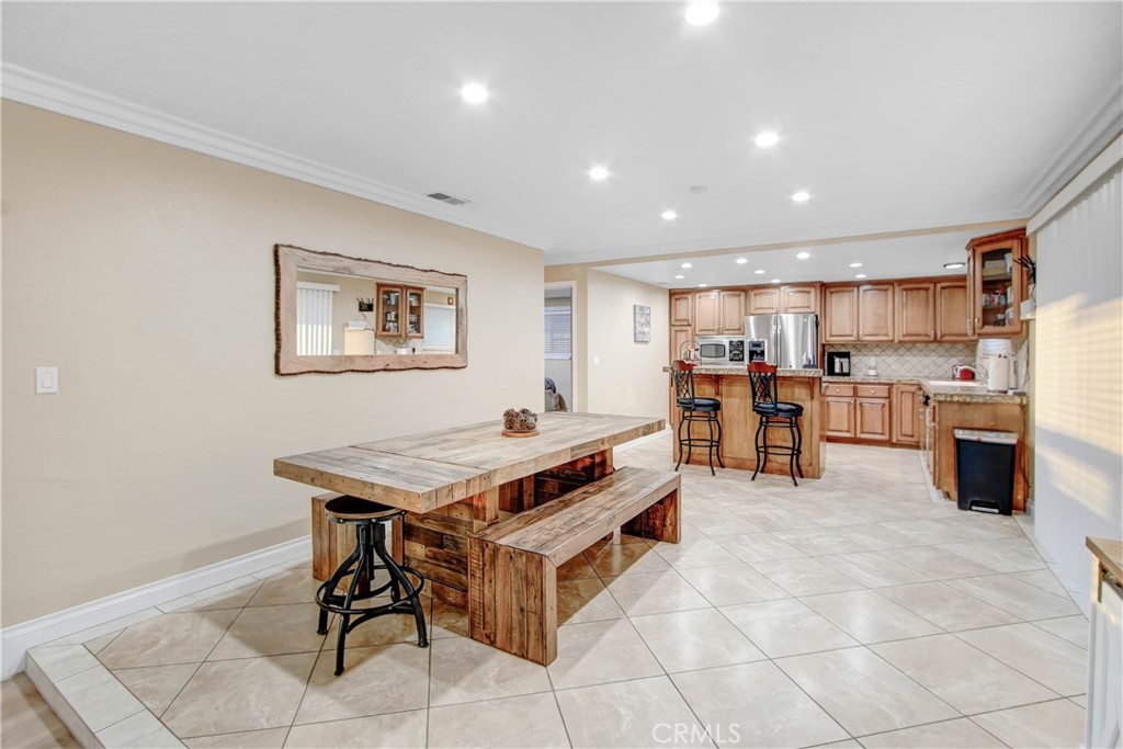 8555 Pigeon Pass Road Moreno Valley, CA 92557 - Photo 9 of 63 a room with stainless steel appliances kitchen island granite countertop a refrigerator and a sink