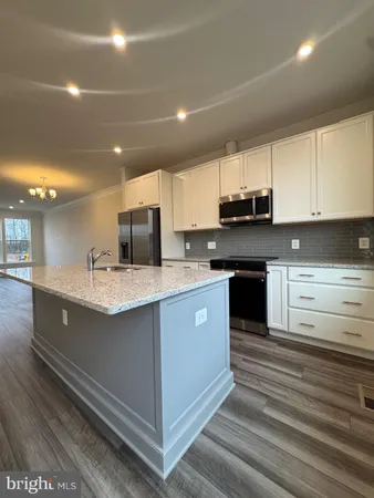 a kitchen with stainless steel appliances granite countertop a sink a stove and a refrigerator
