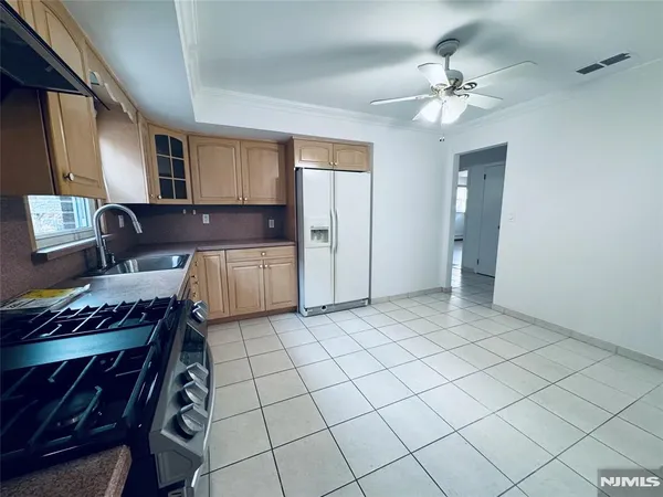 a spacious bathroom with a granite countertop double vanity sink a mirror and a bathtub
