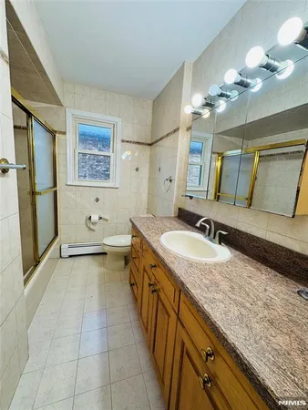 a kitchen with granite countertop a refrigerator a sink and white cabinets
