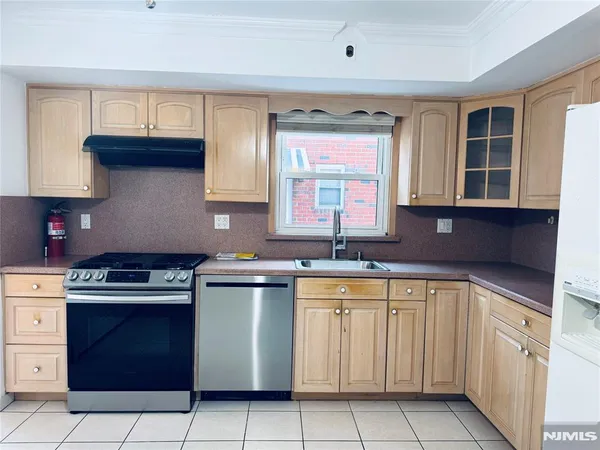 a kitchen with stainless steel appliances a sink stove and cabinets