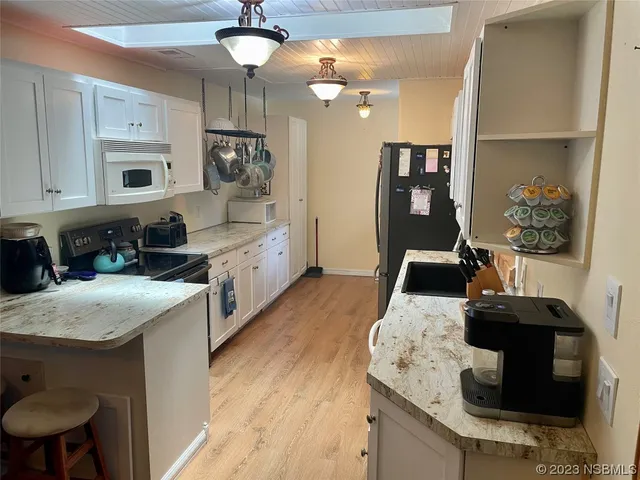 a kitchen with a table chairs sink and cabinets