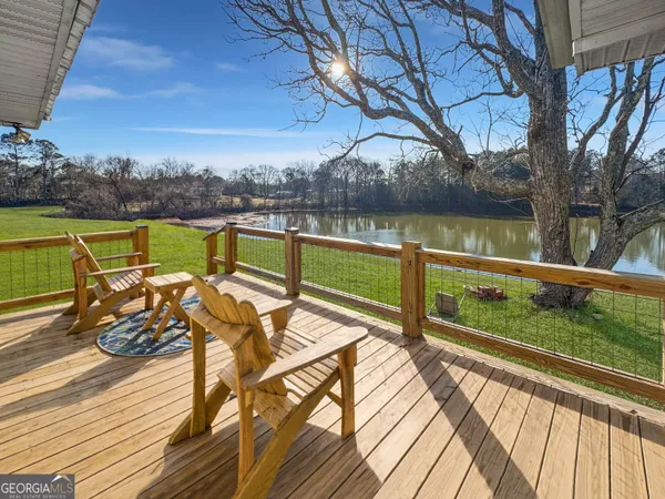 a view of a lake with couches chairs under an umbrella