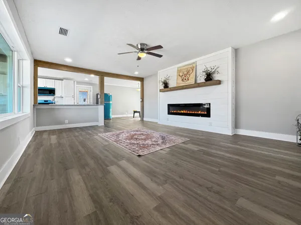 a view of a livingroom with furniture wooden floor a ceiling fan and window