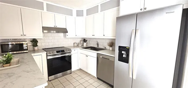 a kitchen with stainless steel appliances granite countertop a stove a refrigerator and a sink