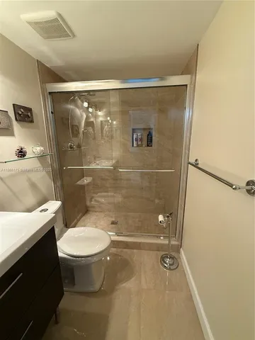 a bathroom with a granite countertop sink toilet and shower