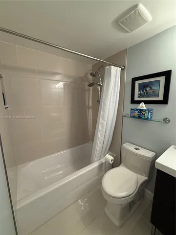 a white toilet sitting next to a bath tub shower