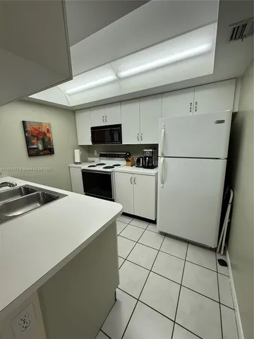 a kitchen with stainless steel appliances a stove a sink and a microwave