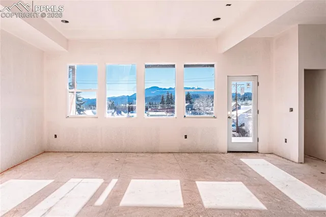 a view of an empty room with a window and brick walls