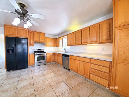 1037 South Ranger Street Ridgecrest, CA 93555 - Photo 18 of 26 a kitchen with stainless steel appliances granite countertop a refrigerator and a sink