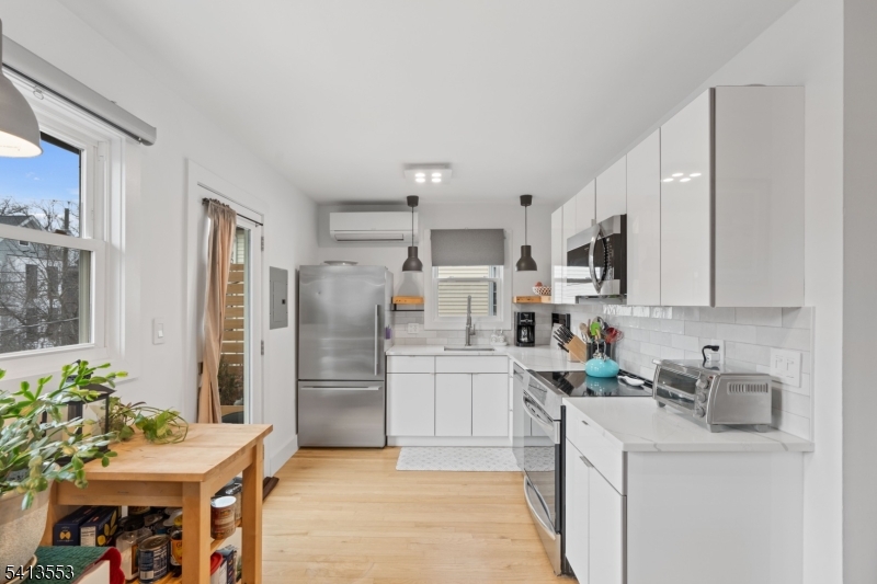 5 Washington Street Montclair, NJ 07042 - Photo 7 of 18 a kitchen with stainless steel appliances a refrigerator sink and white cabinets