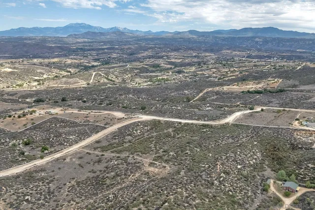a view of a dry yard with wooden floor and fence