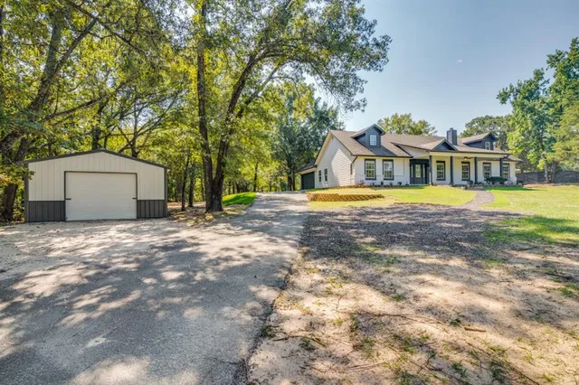 a front view of a house with a yard and trees