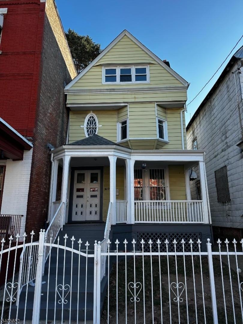 a front view of a house with iron fence