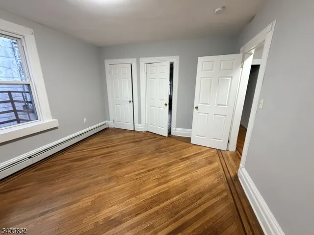 a view of empty room with wooden floor and cabinet