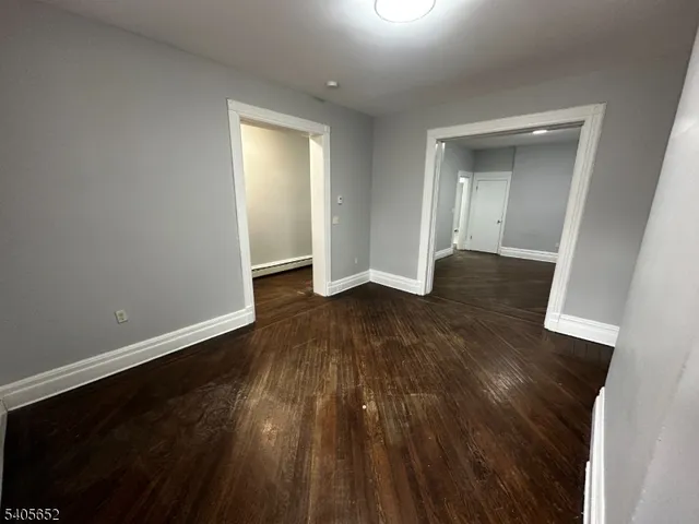 an empty room with wooden floor and closet