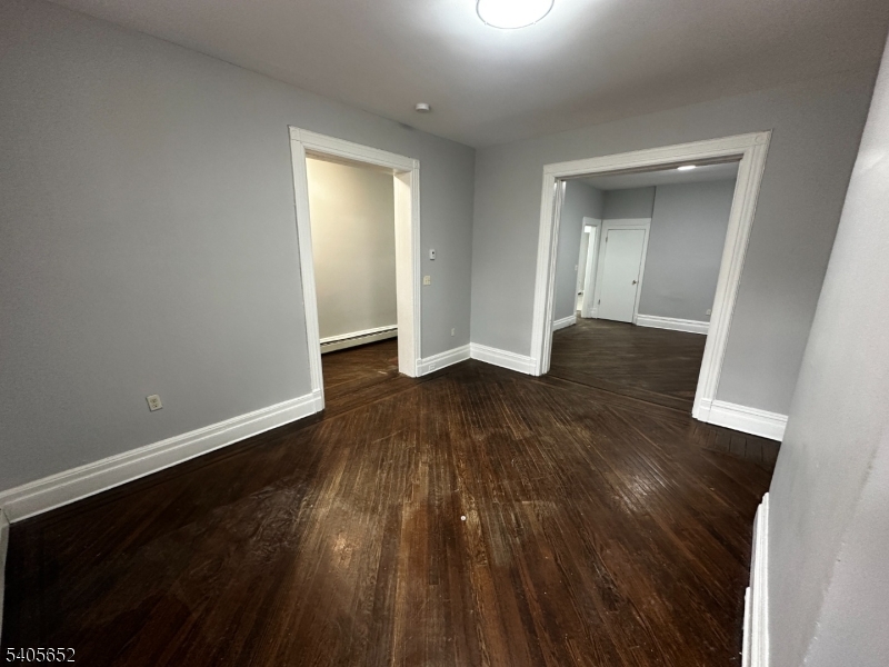 213 North 7th Street Newark, NJ 07107 - Photo 2 of 20 an empty room with wooden floor and closet