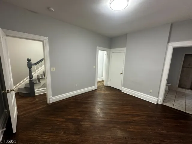 an empty room with wooden floor and mirror