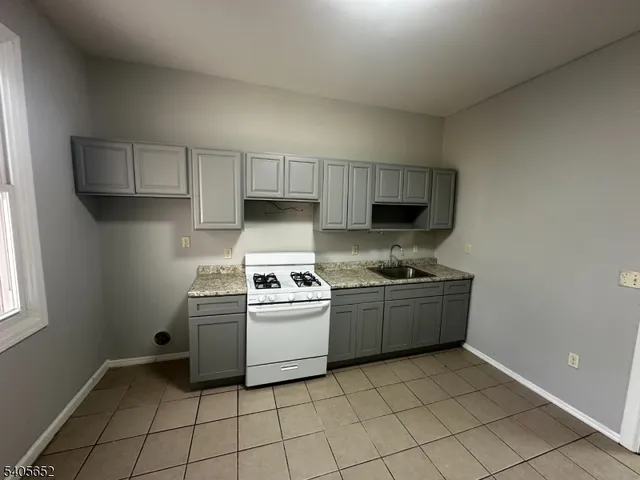 a kitchen with granite countertop a stove a sink and a granite counter tops
