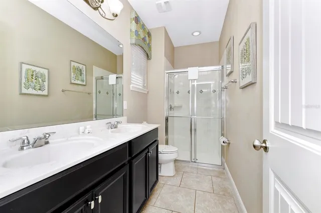 a bathroom with a double vanity sink a mirror and a shower
