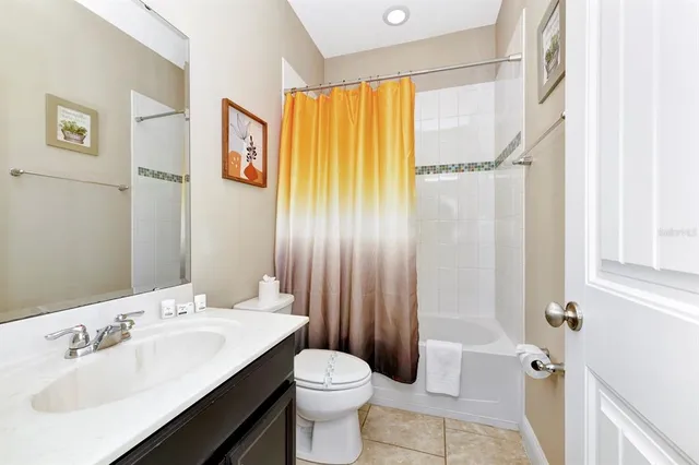 a bathroom with a sink a toilet and shower curtain