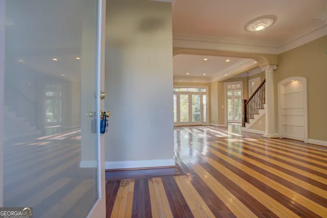 a view of empty room with wooden floor and fan