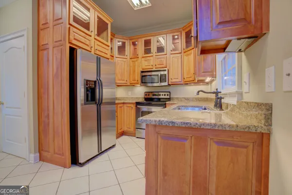 a kitchen with stainless steel appliances granite countertop a refrigerator and a sink