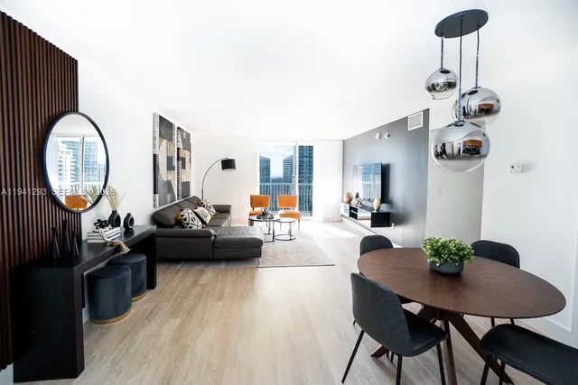a living room with furniture a chandelier and a dining table