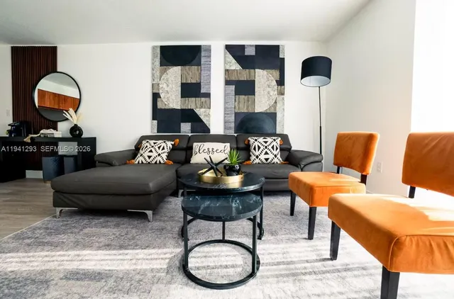 a living room with furniture and wooden floor