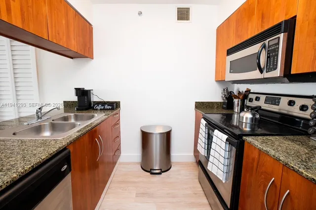 a kitchen with sink a microwave a stove and refrigerator