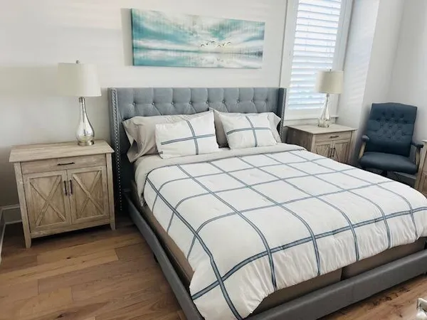 a bedroom with a white bed dresser and a window