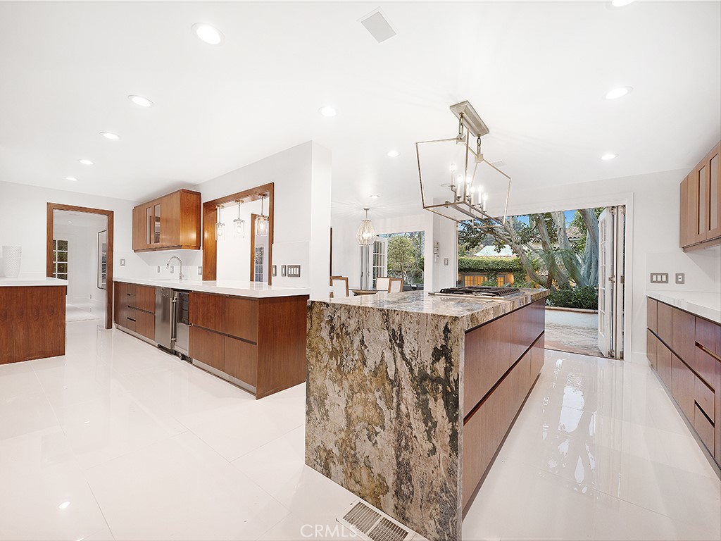 726 Foothill Road Beverly Hills, CA 90210 - Photo 11 of 59 a large kitchen with kitchen island granite countertop wooden cabinets and a granite counter tops