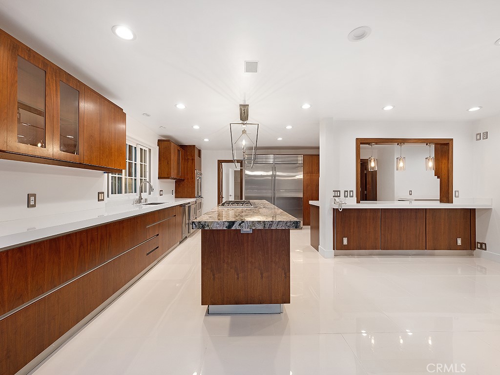 726 Foothill Road Beverly Hills, CA 90210 - Photo 12 of 59 a large kitchen with stainless steel appliances a large counter top a stove and a sink