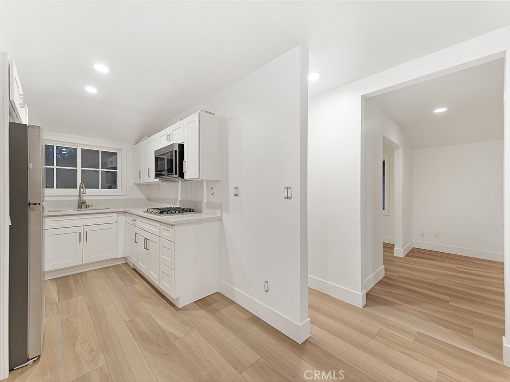 726 Foothill Road Beverly Hills, CA 90210 - Photo 35 of 59 a kitchen with granite countertop white cabinets and white appliances