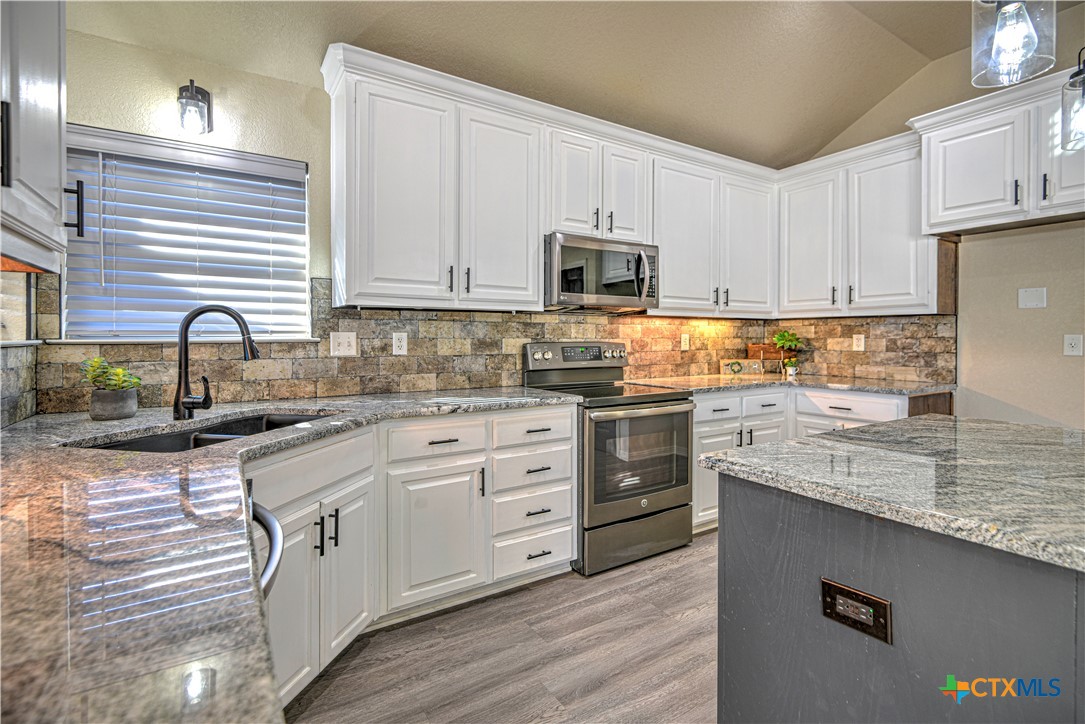 3106 Pitchfork Circle Belton, TX 76513 - Photo 11 of 45 a kitchen with granite countertop white cabinets sink and stainless steel appliances