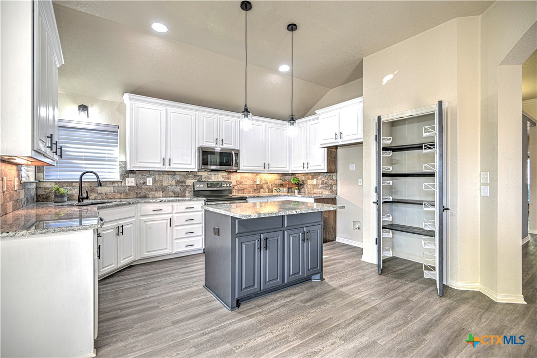 3106 Pitchfork Circle Belton, TX 76513 - Photo 12 of 45 a kitchen with stainless steel appliances granite countertop a refrigerator a sink dishwasher a stove and white cabinets with wooden floor