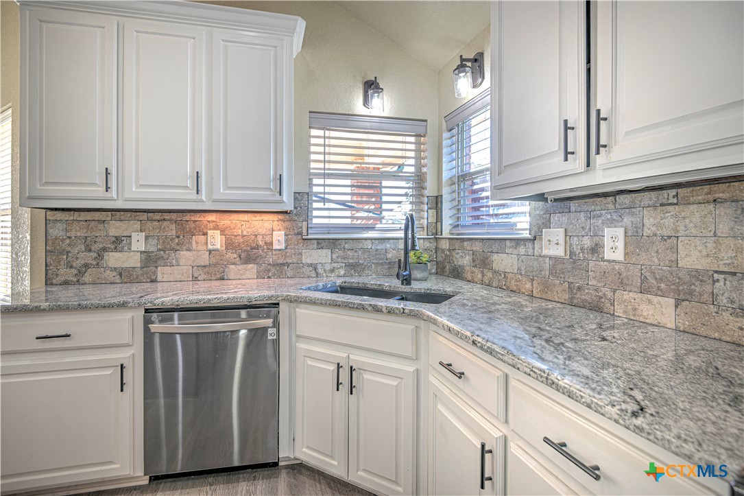 3106 Pitchfork Circle Belton, TX 76513 - Photo 14 of 45 a kitchen with granite countertop white cabinets and white stainless steel appliances with a window