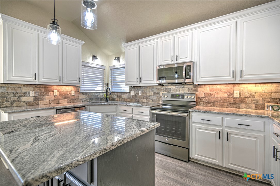 3106 Pitchfork Circle Belton, TX 76513 - Photo 15 of 45 a kitchen with granite countertop a stove sink and cabinets