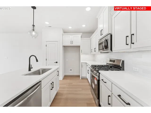 a kitchen with stainless steel appliances a sink stove and cabinets